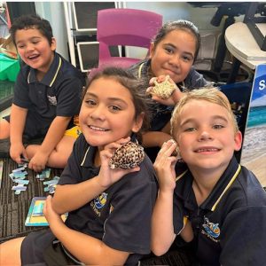 Teacher and students exploring marine animal shells during a Queensland school incursion